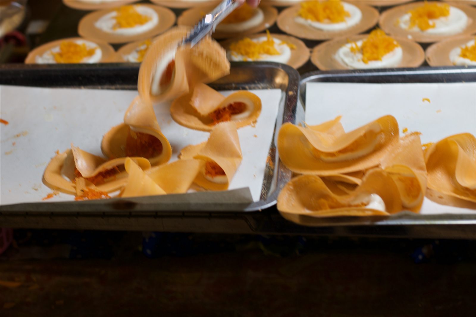 Street Food & Tuk-Tuk — crispy filled crepes being folded at a dessert stall