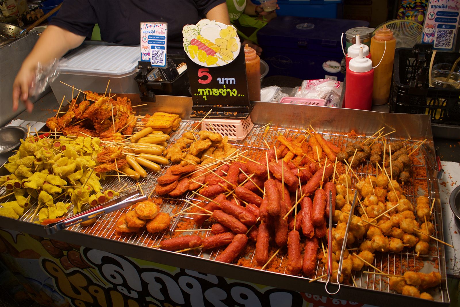Street Food & Tuk-Tuk — skewered sausages and fish balls laid out on a grill